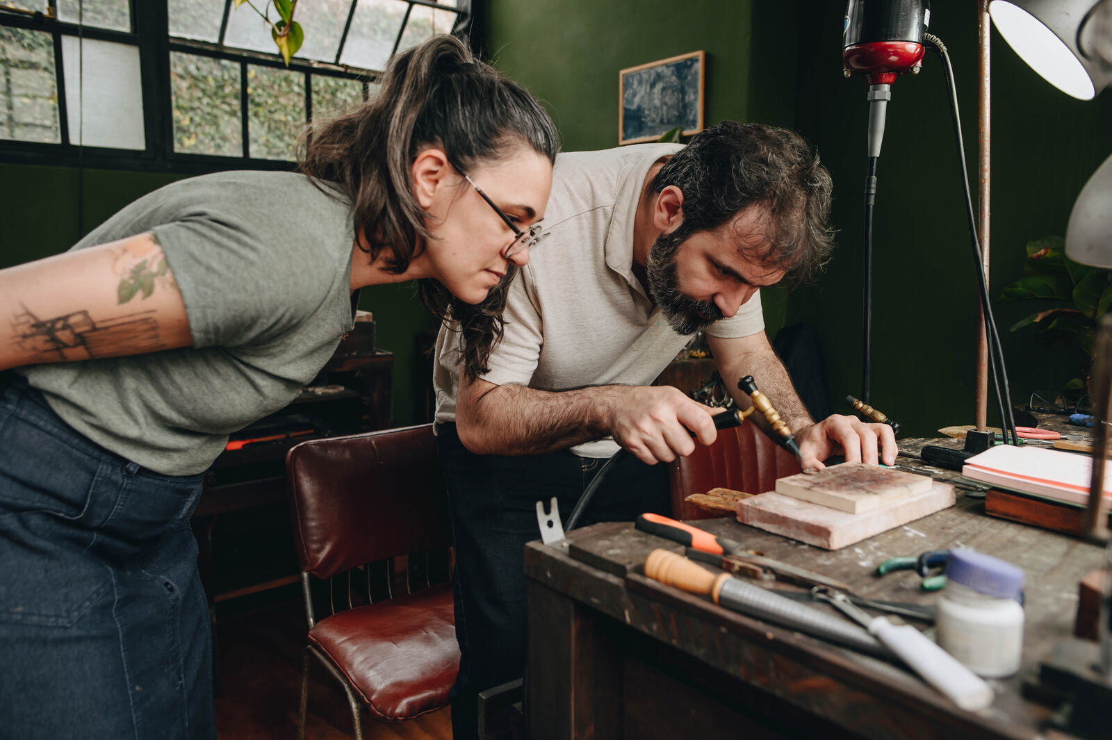 Pareja trabajando junto a la orfebre en el taller