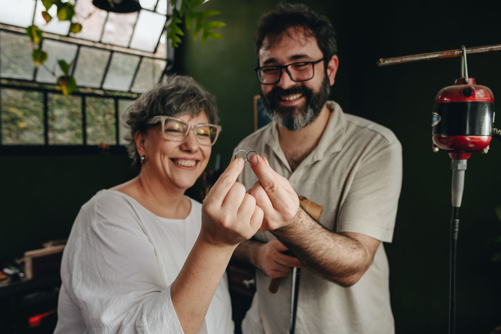 Pareja trabajando junto a la orfebre en el banco de taller