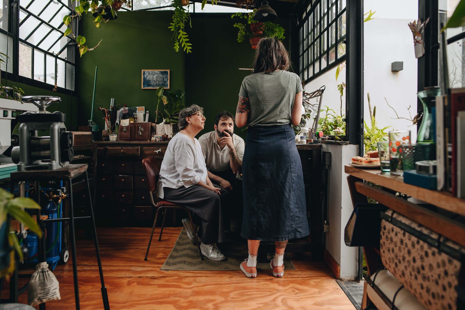 Pareja creando sus alianzas de casamiento junto a la orfebre Pepu (Paisajita) en el invernadero de Taller Jardín Secreto, Buenos Aires