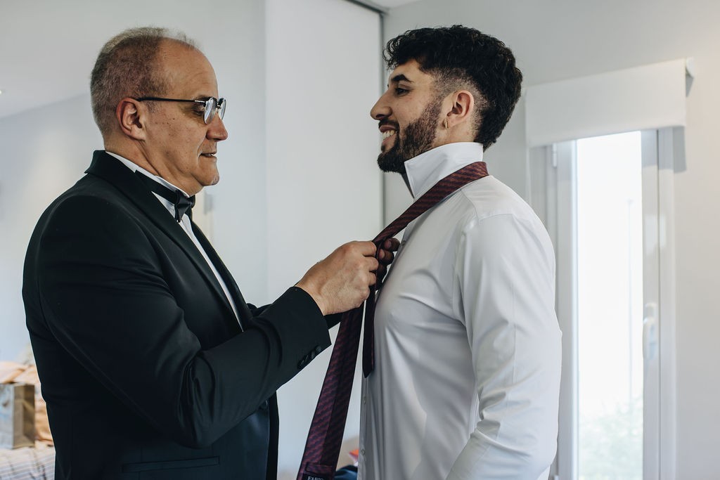 El padre del novio ajustándole la corbata