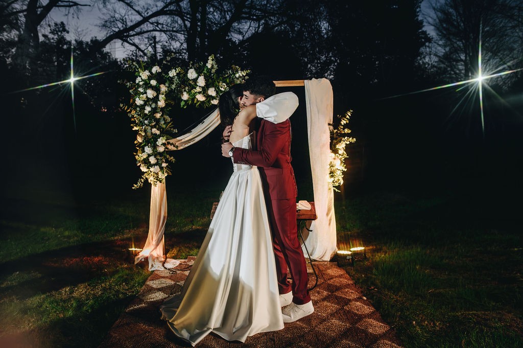 La pareja en el arco de flores, de noche