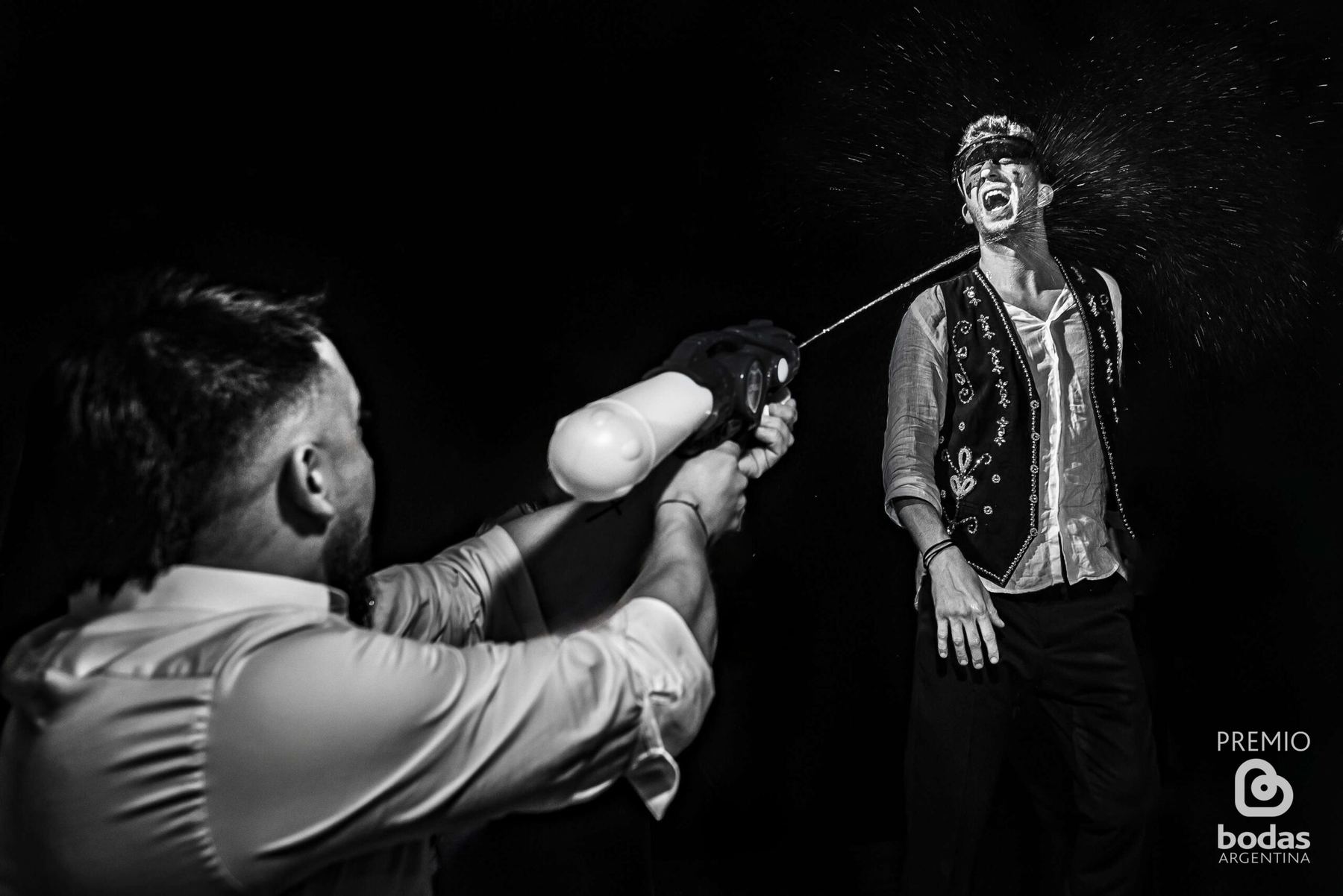 Broma con pistola de agua en la fiesta de casamiento, blanco y negro