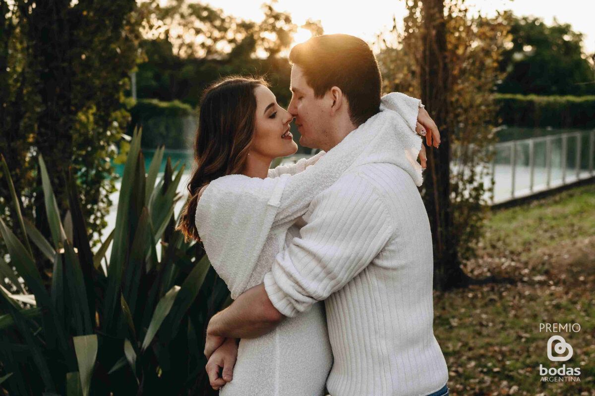 Pareja abrazada al atardecer en la sesión de compromiso
